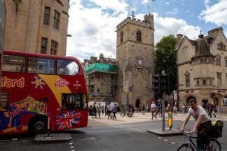 Guide Friday City Sightseeing Oxford tour bus outside Carfax Tower, Oxford